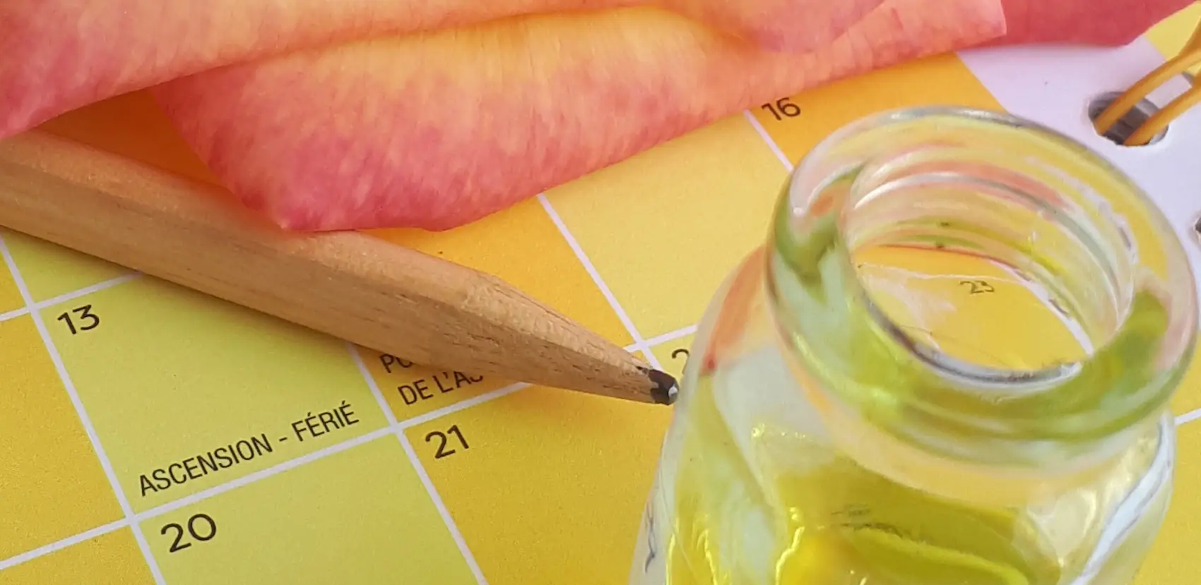 flacon essence aromatique sur joli calendrier aromatherapie jaune avec crayon de bois